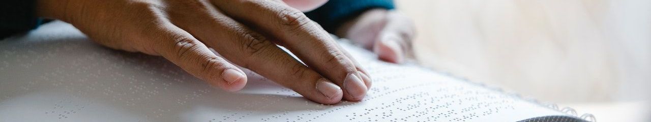 A hand of a person reading braille.