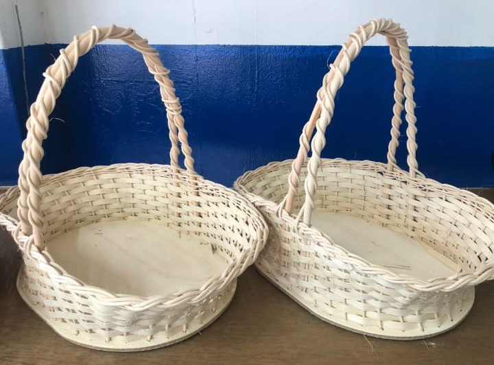 A white basket with handles sitting on a brown table.