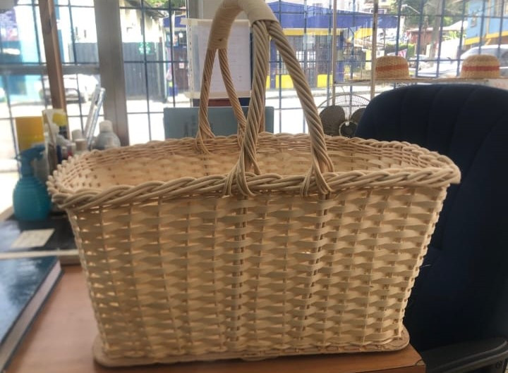 A white basket with handles sitting on a brown table .